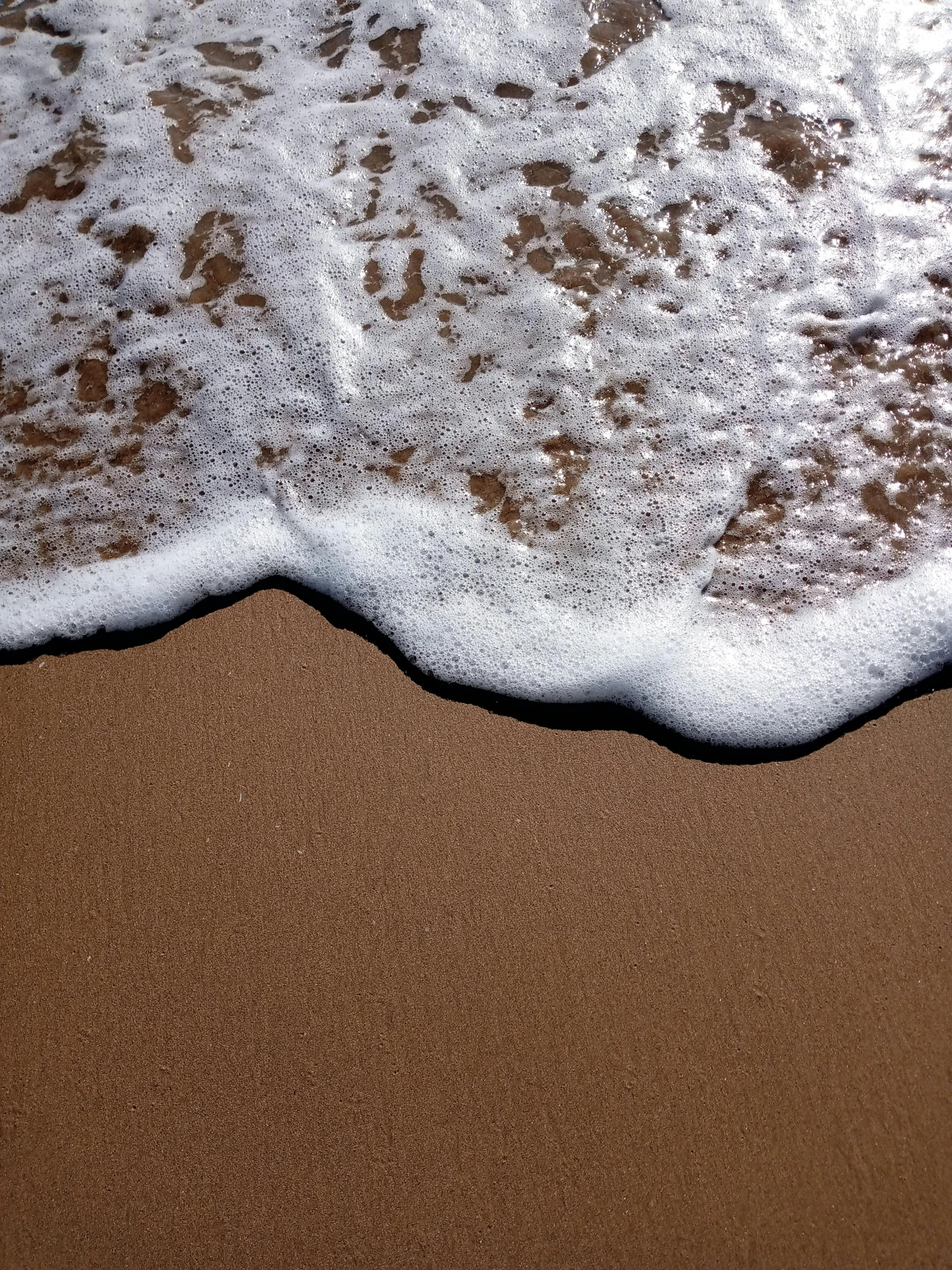 waves are rolling on a sandy beach