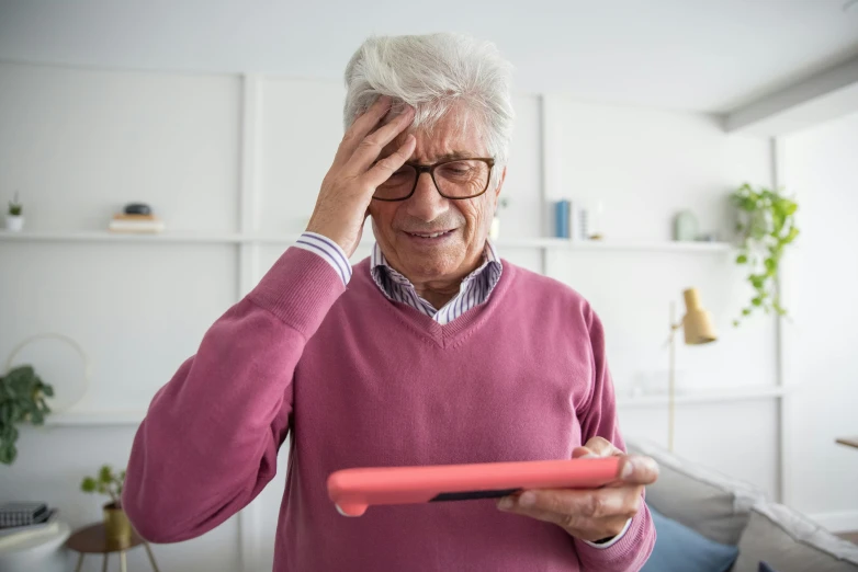 a man in glasses using his red plastic toothbrush