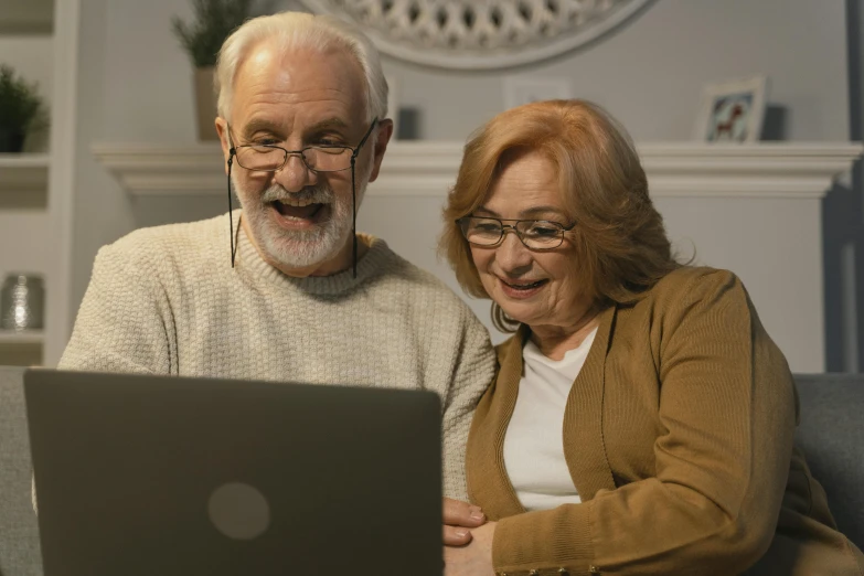 an older couple look at a laptop screen