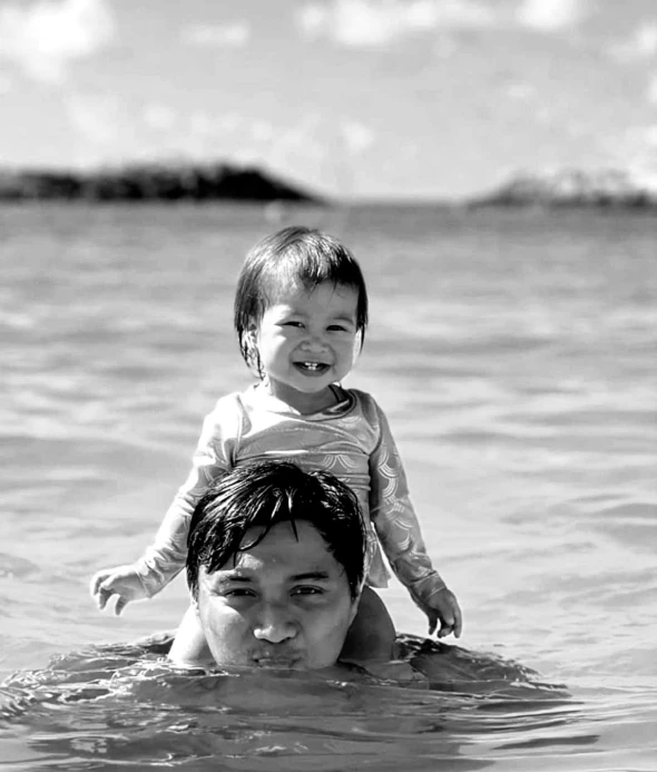 an image of a man and a child floating in the water