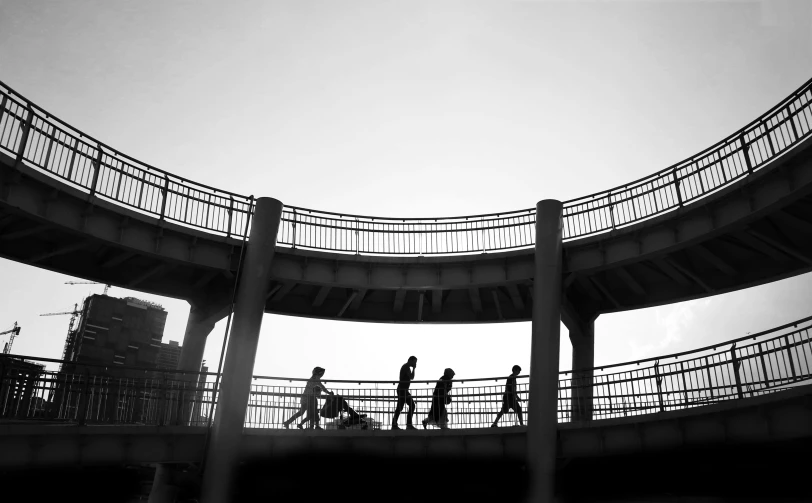 a bridge with people crossing it and some people riding bikes