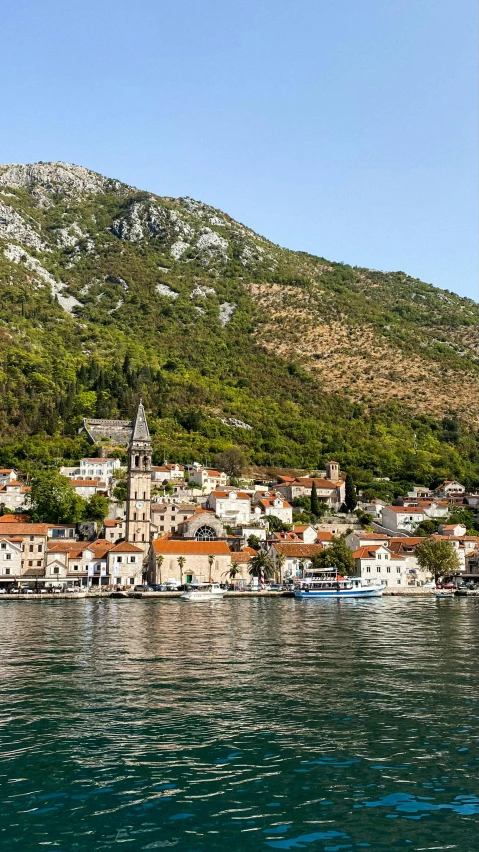 a small village on the shore next to a lake with boats