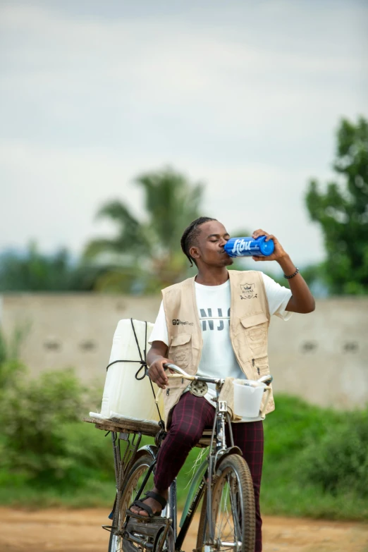 a man with glasses and a white bag drinking a beverage