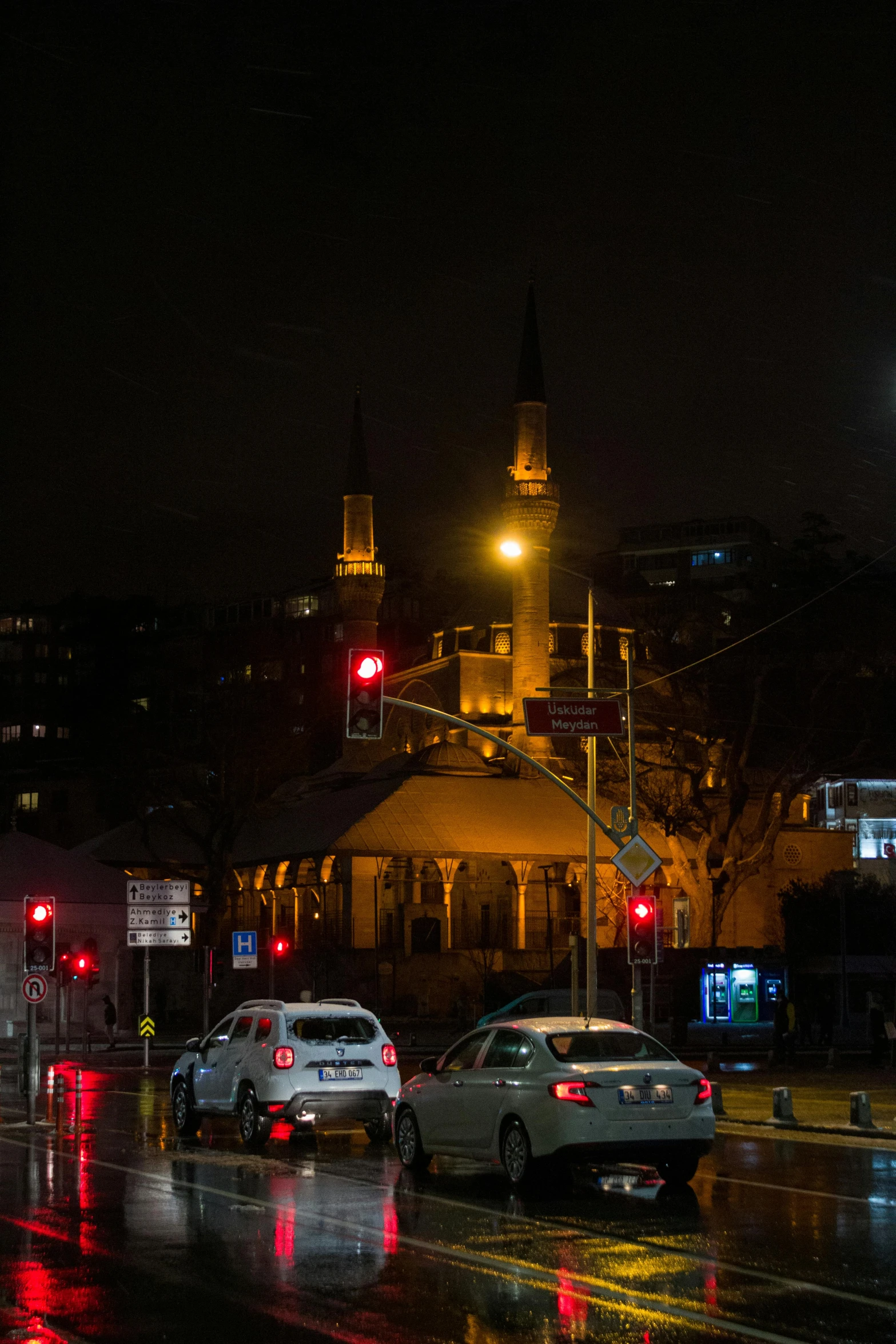 city street with cars and traffic lights at night