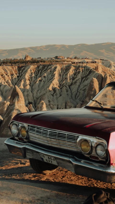 a car is parked in front of a cliff