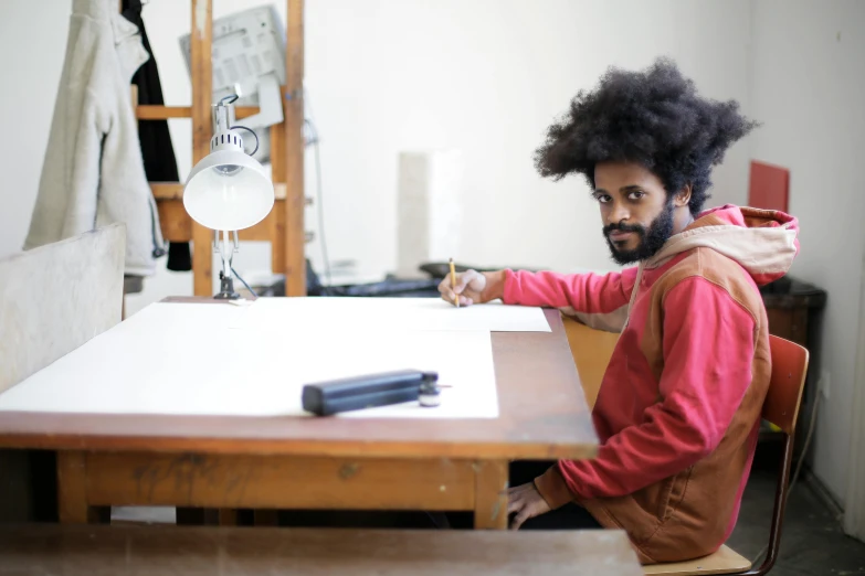 a man with curly hair sitting at a table