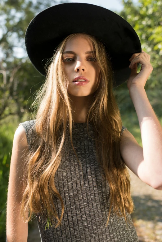 the girl wearing a black hat poses for the camera