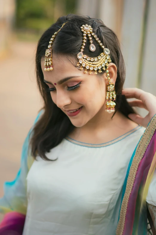 a woman smiles while wearing a headpiece made of beads and stones