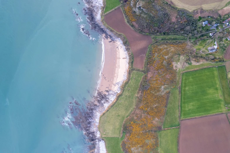 an aerial view of some land near the water