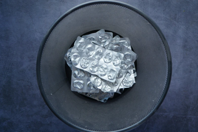 a silver material in a mesh holder on a black background