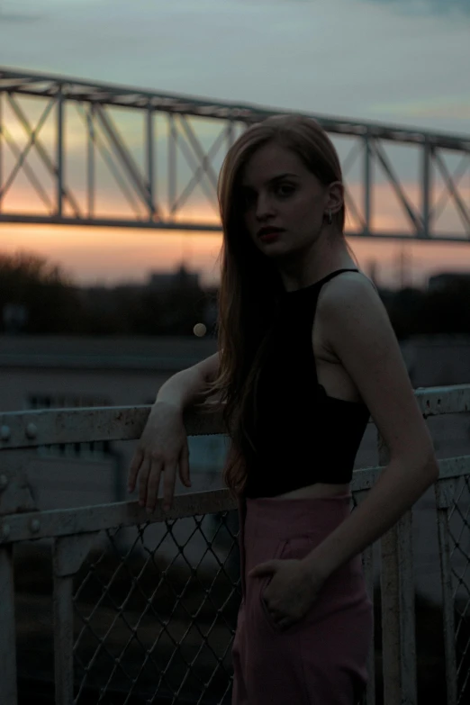 a young woman posing in front of a sunset