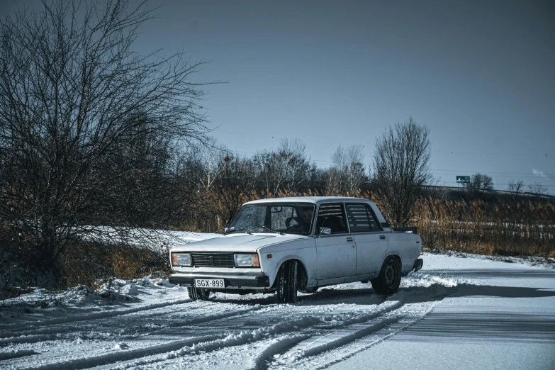 the old pickup truck is parked on the side of a snow - covered road