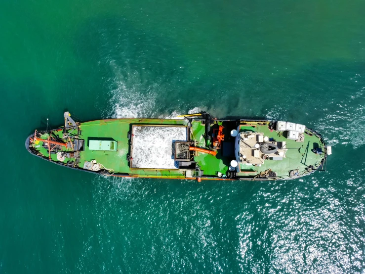 an aerial view of a boat, which has landed on the green water