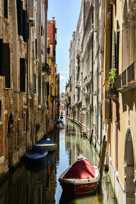 two rowboats floating in the water next to tall buildings