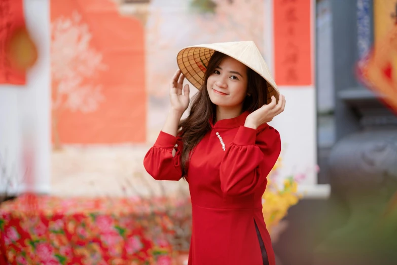 an asian woman posing for a po wearing a sun hat