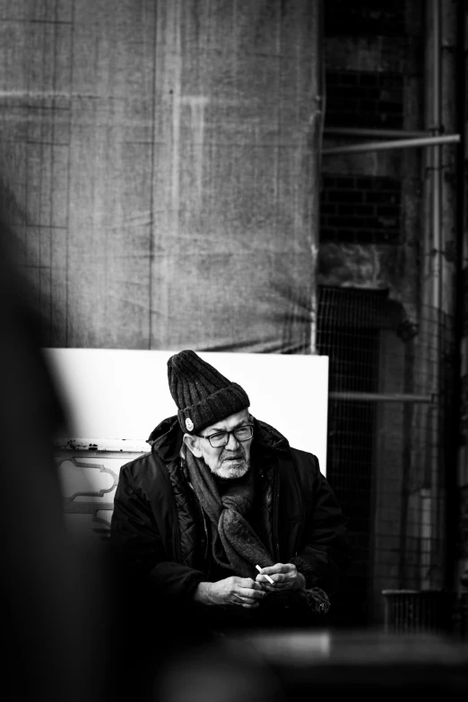 a man sits on a bench outside in the day