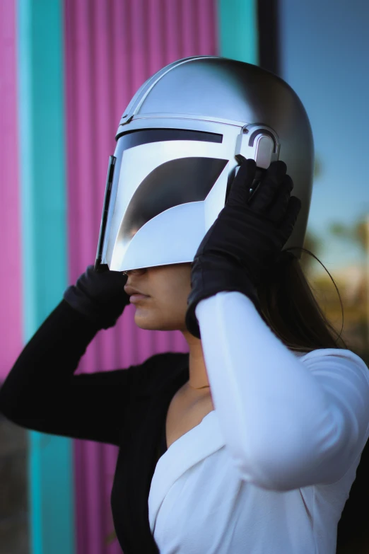 a woman wearing a star wars helmet is covering her eyes