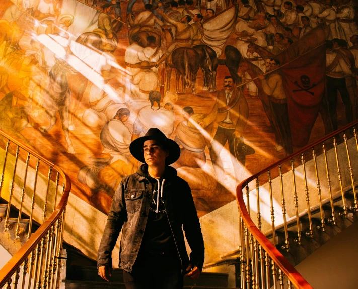 a man standing on stairs in front of a large mural