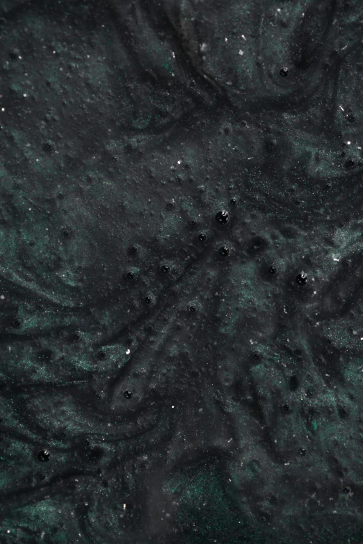 an image of some dark colored material with water bubbles