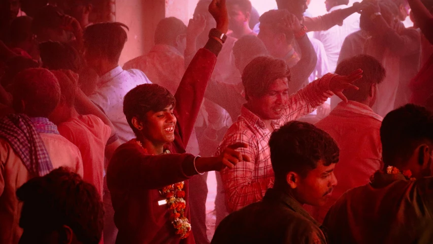 a crowd of people in the dark dancing with colored smoke