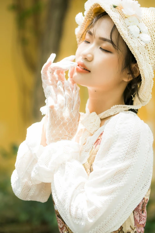 a woman in a white dress is blowing on her hand