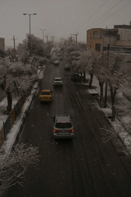 two cars in a snow storm driving down the road