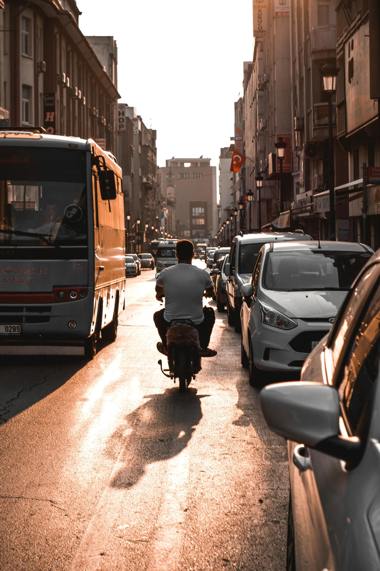 man riding a motorcycle down the middle of a busy street