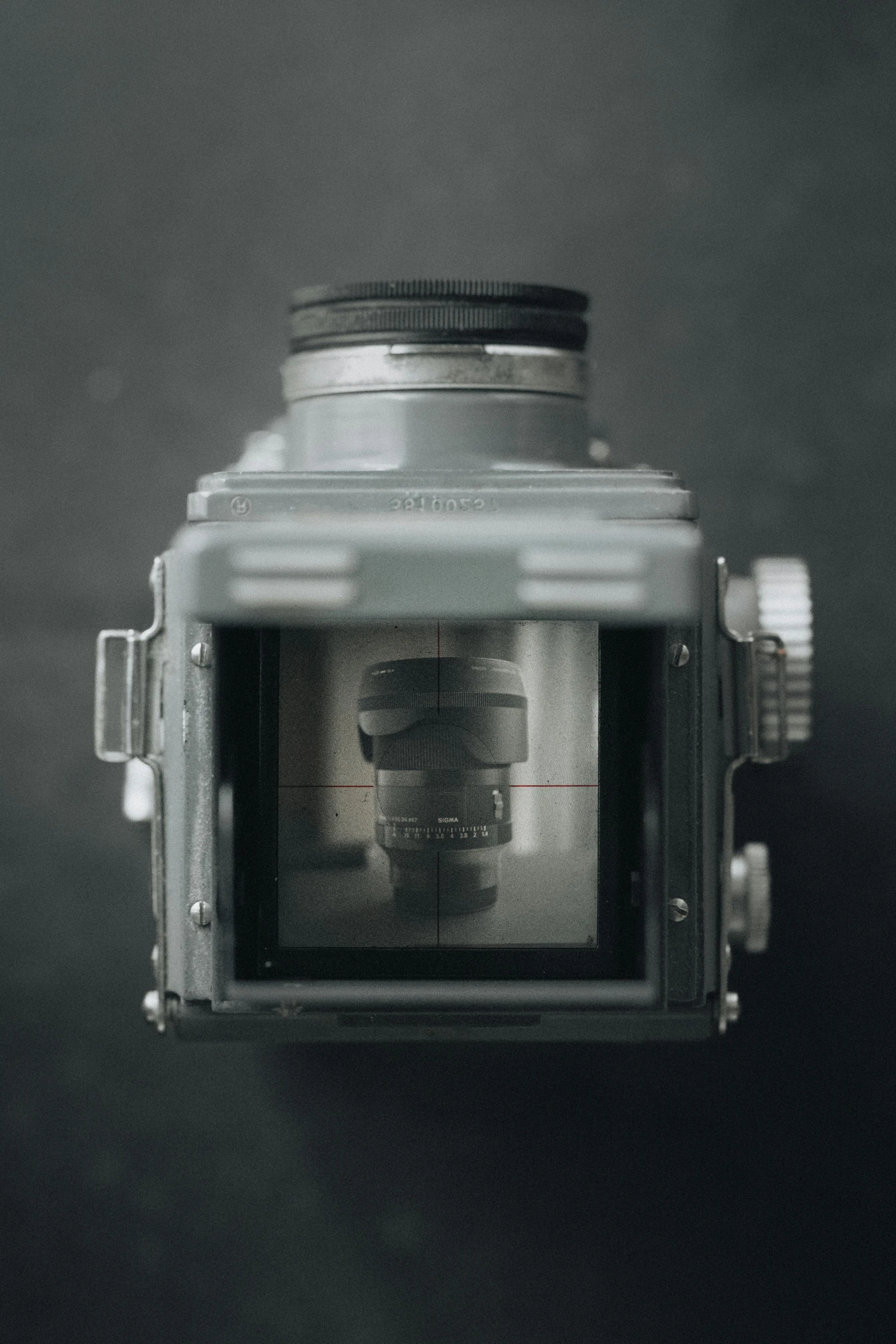 a close - up pograph of a camera showing the reflection of people on it