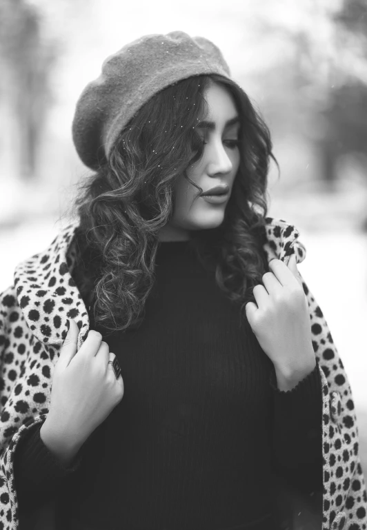 a woman in a black dress and leopard coat is wearing her hair in waves