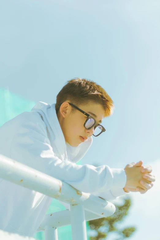 a boy is standing on a ledge near a railing