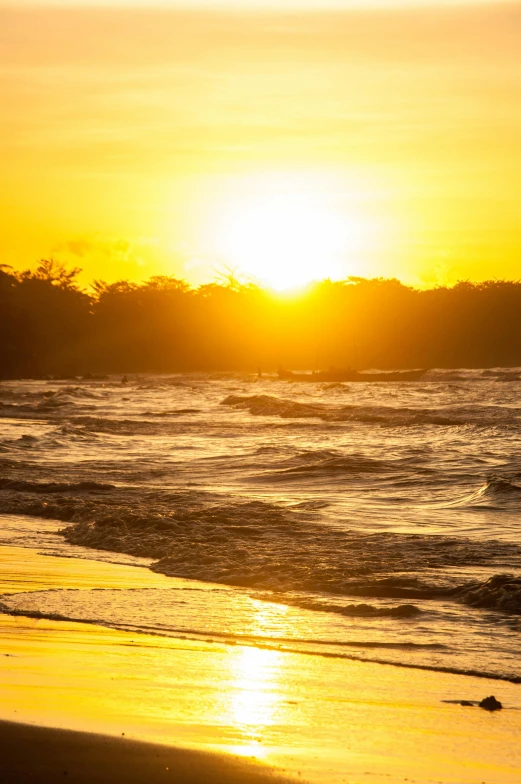 a surf board on the beach during a sunset