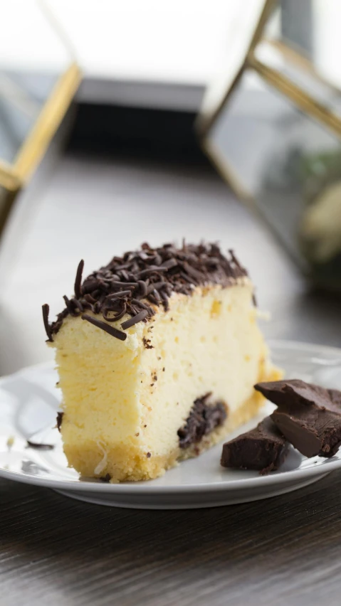 a piece of cake with a chocolate topping on it sitting on a white plate