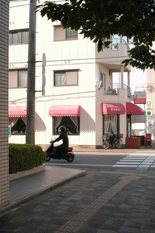 the motorcyclist is coming down the street and leaving the el