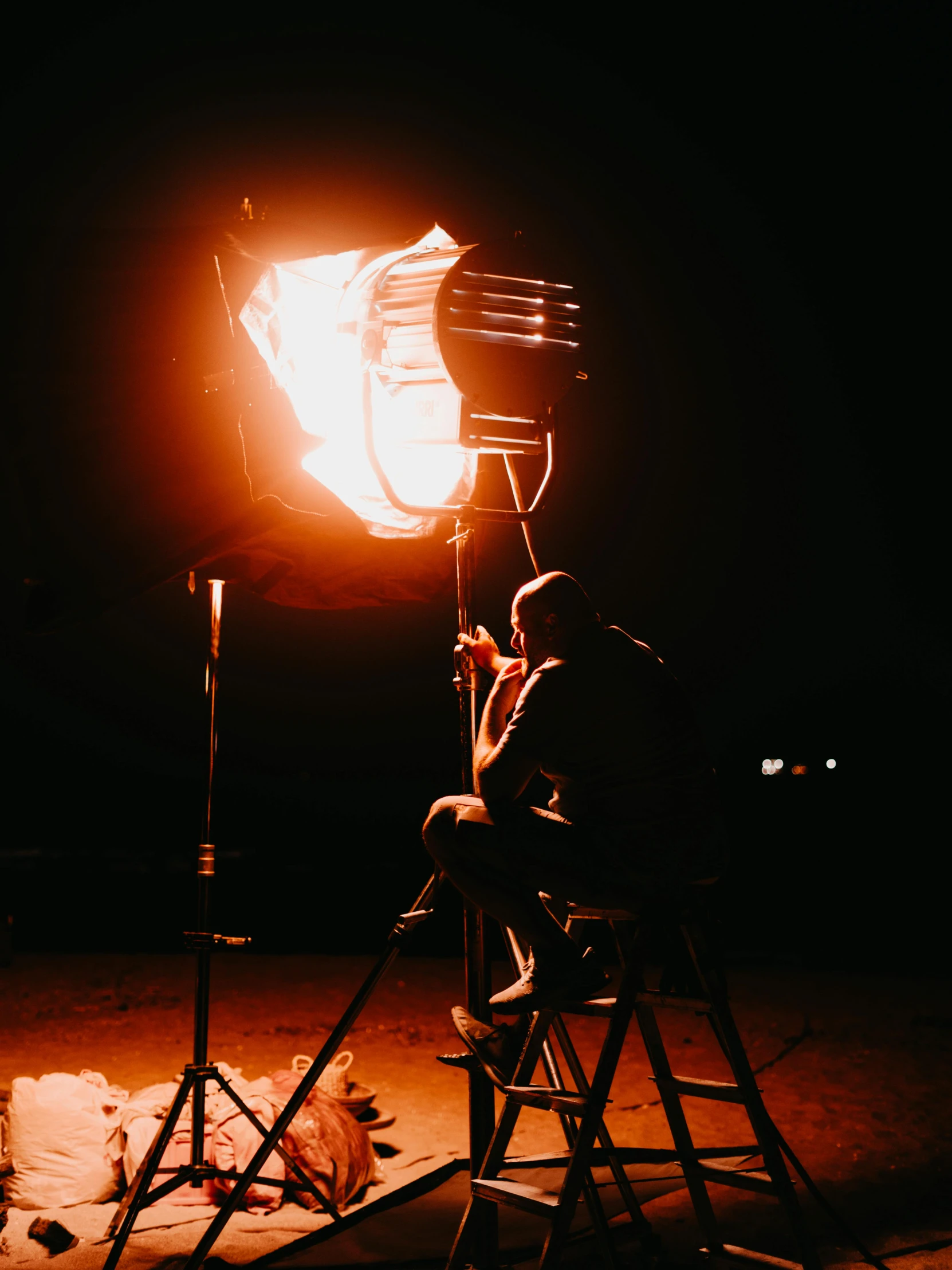 man sitting in chair next to large flame with camera