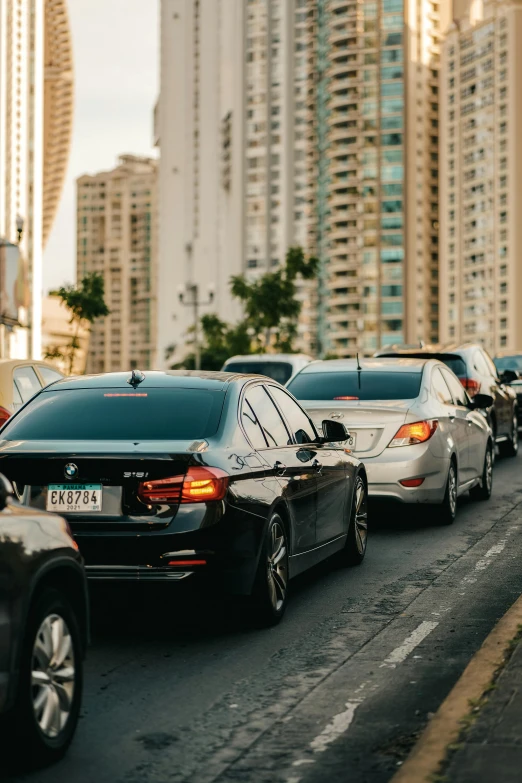 some cars driving down a city street near tall buildings