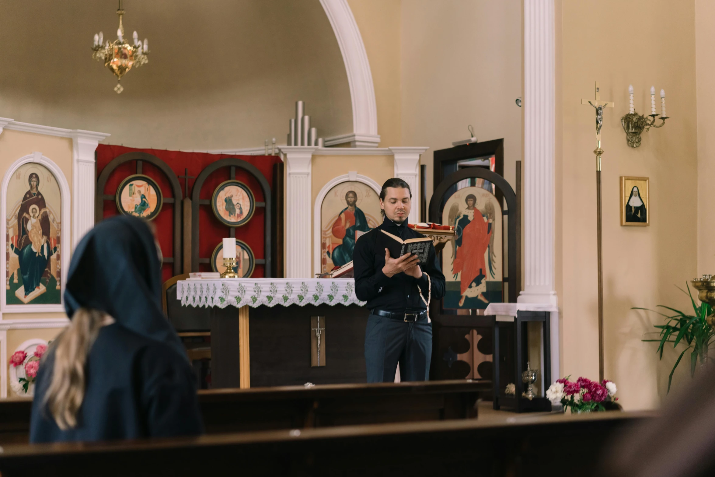 a young priest is reading from the bible