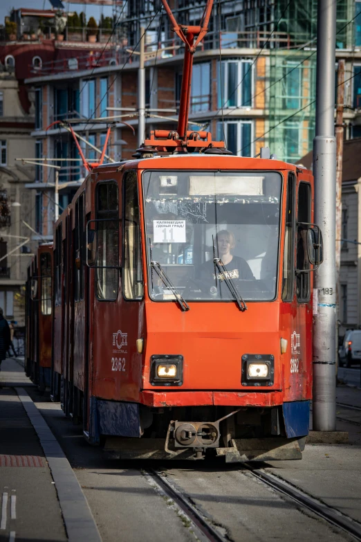 a red trolley rides down a train track