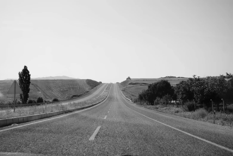 the road is wide and empty with some buildings in it