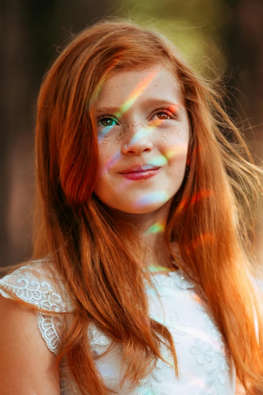 girl with red hair and rainbow make up smiling