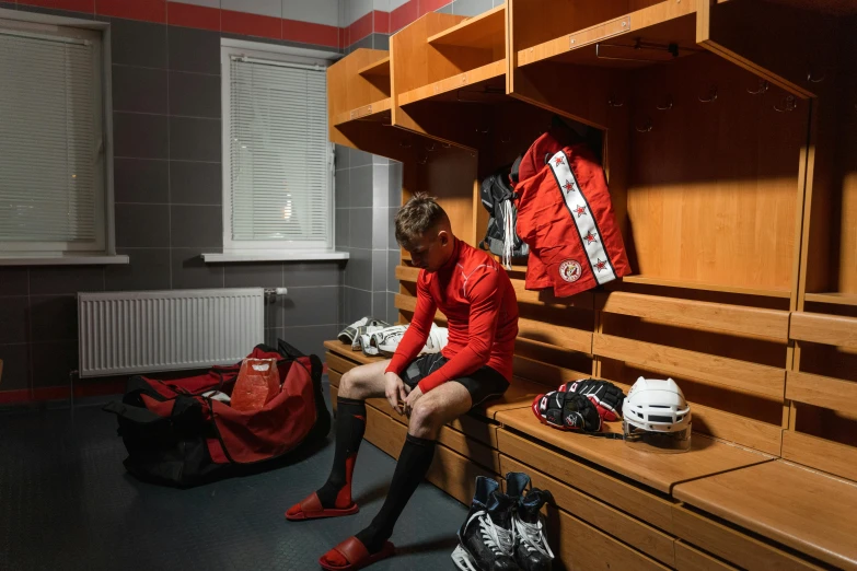 the man sits near the shelves of his lockers