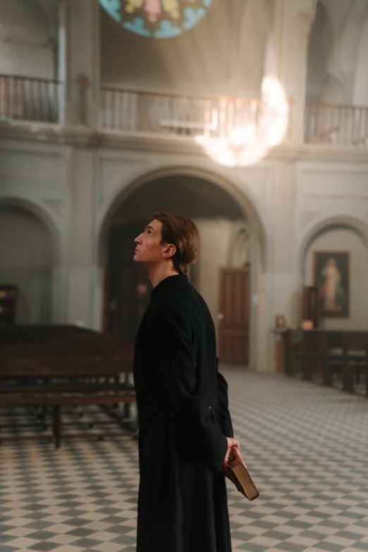 woman standing in old church with large clock hanging from ceiling