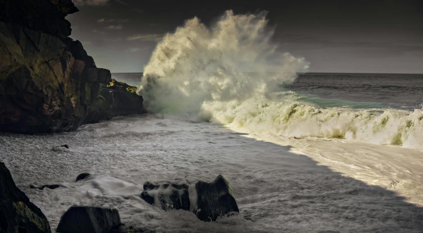 a rock cliff with a big wave breaking off it