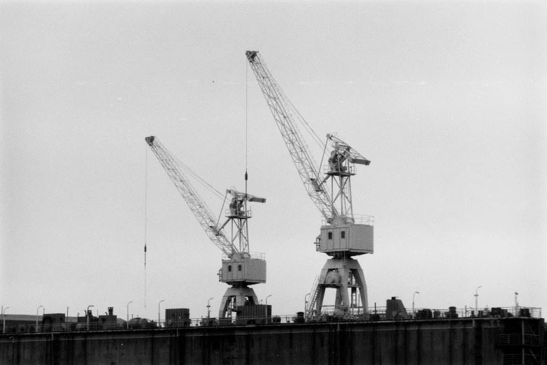 black and white pograph of the cranes atop a building