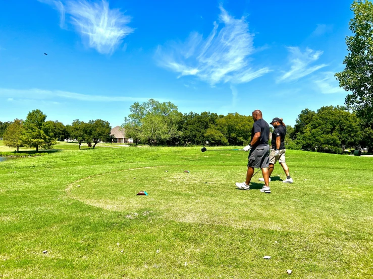 two men with bags are playing golf in the sun
