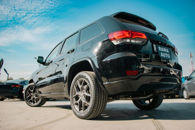 the rear view of a black jeep at a parking lot