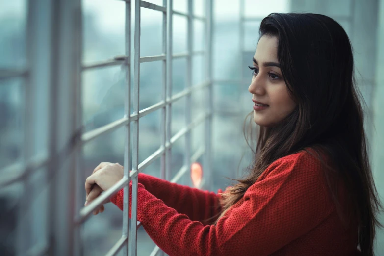 woman leaning against a wall in the middle of a window