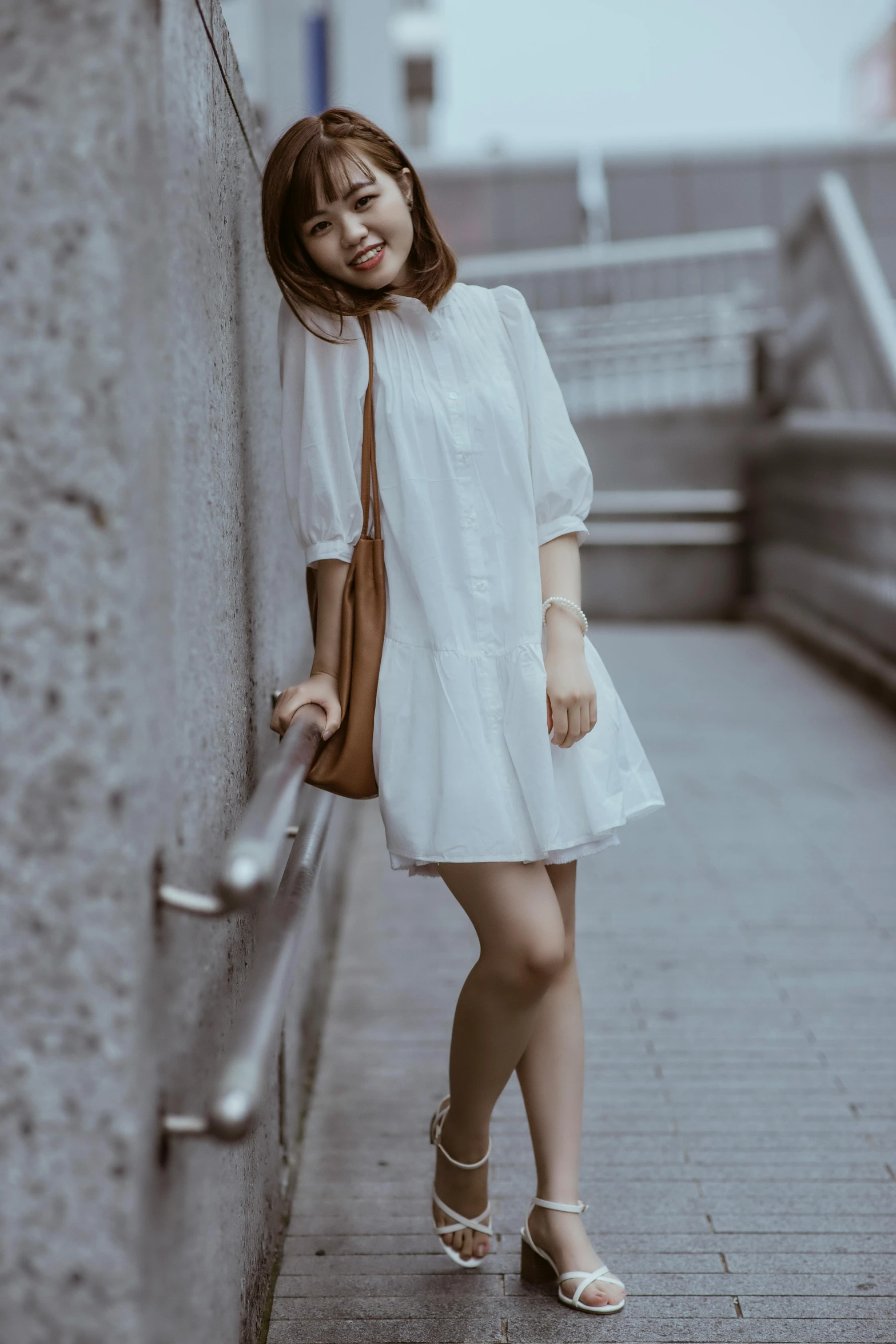 a young woman leaning against a building in an image of someone