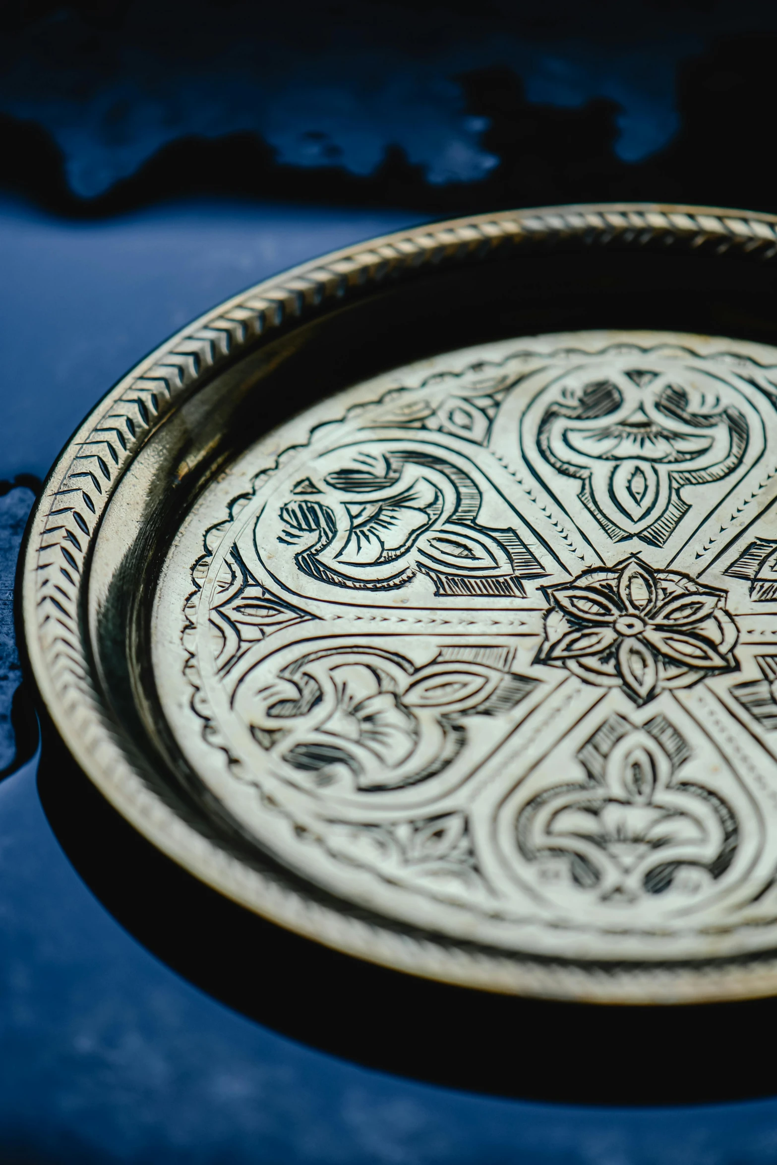 an intricate metal plate in a blue hue