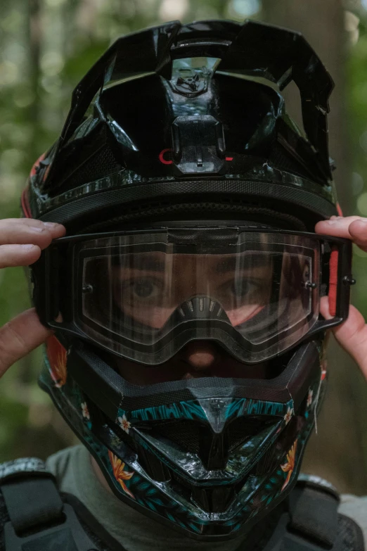 a man holds his helmet on top of his face