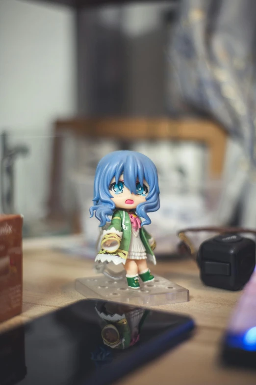 toy figure sits on the table beside a cell phone